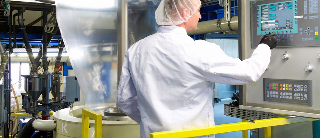 Mitarbeiter in Hygienekleidung an einer Blasfolienanlage